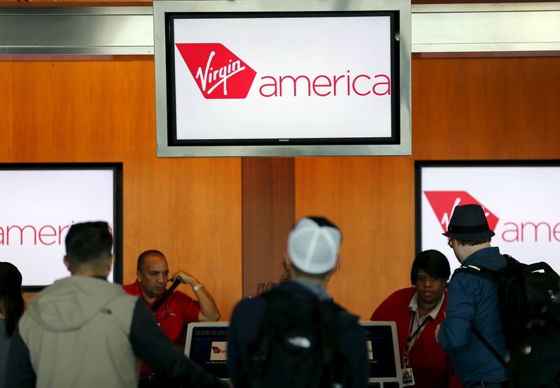 Passengers check in for their flights at the Virgin America