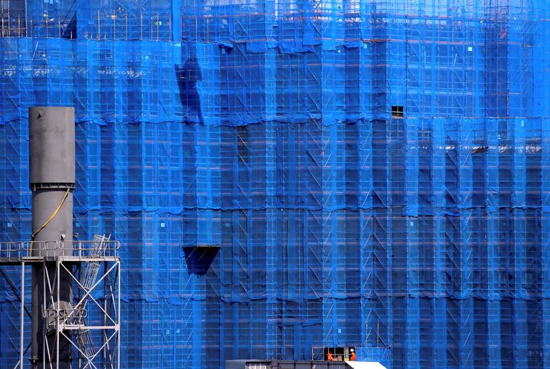FILE PHOTO: Construction workers go about their day near scaffolding