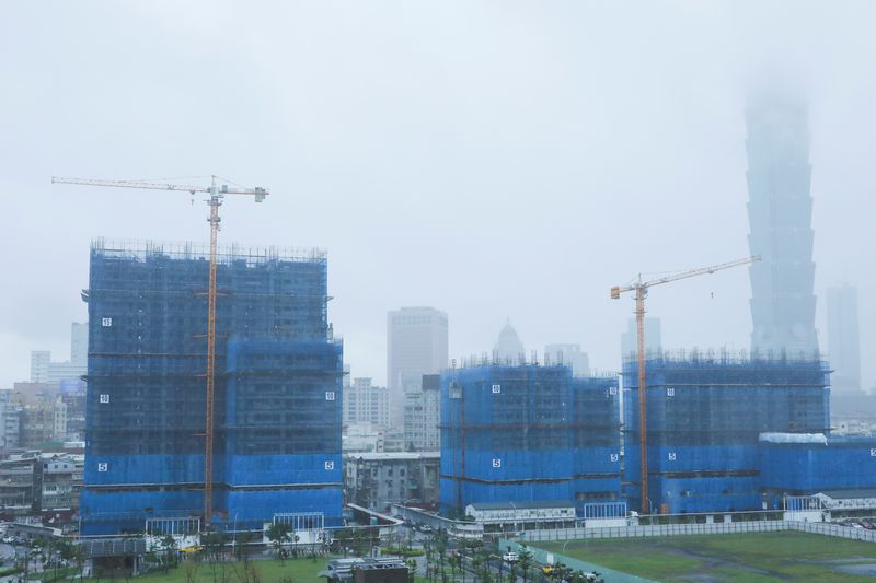 Cranes are pictured during a rainy day at a construction