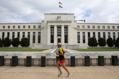 FILE PHOTO: A jogger runs past the Federal Reserve building