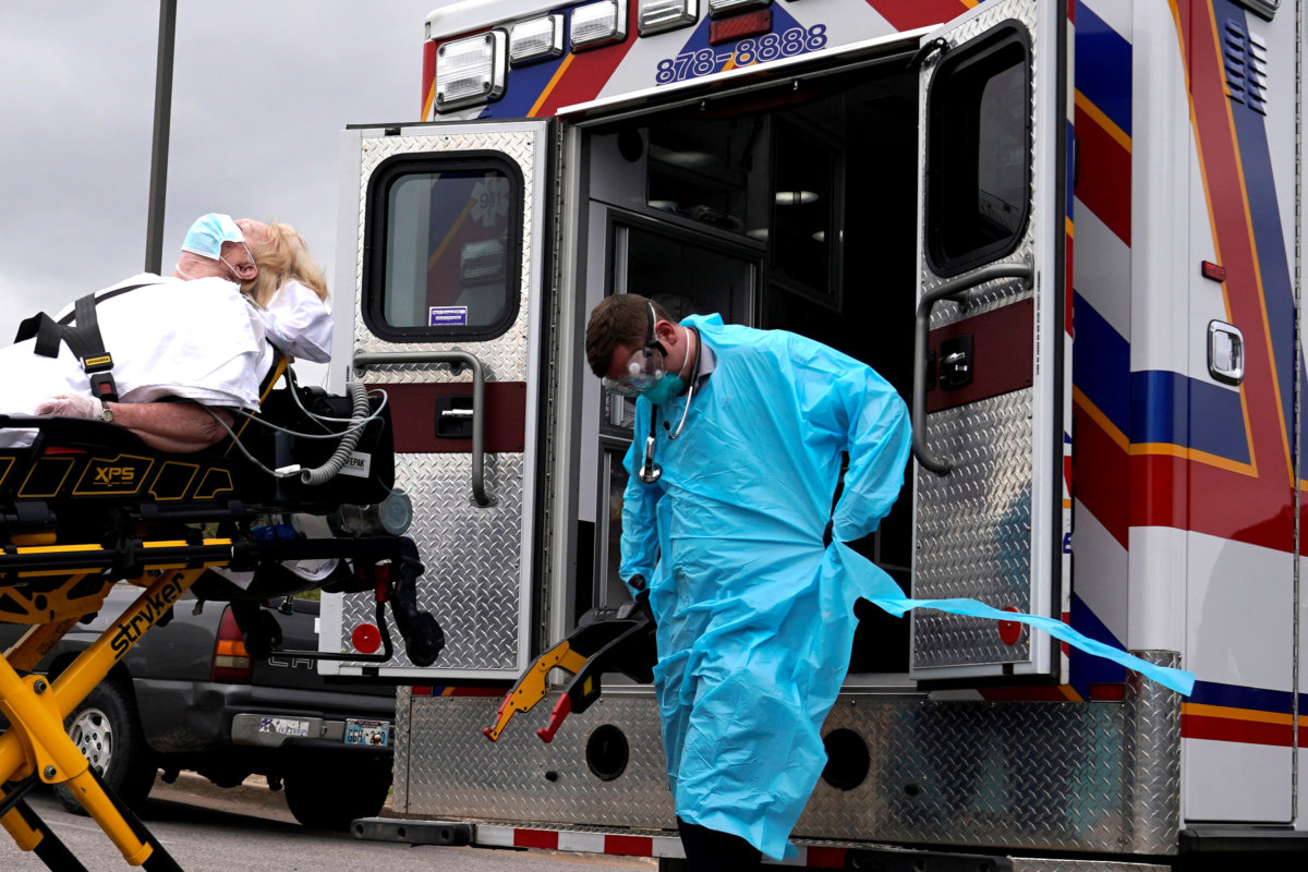 FILE PHOTO:  REACT EMS paramedics load a potential coronavirus