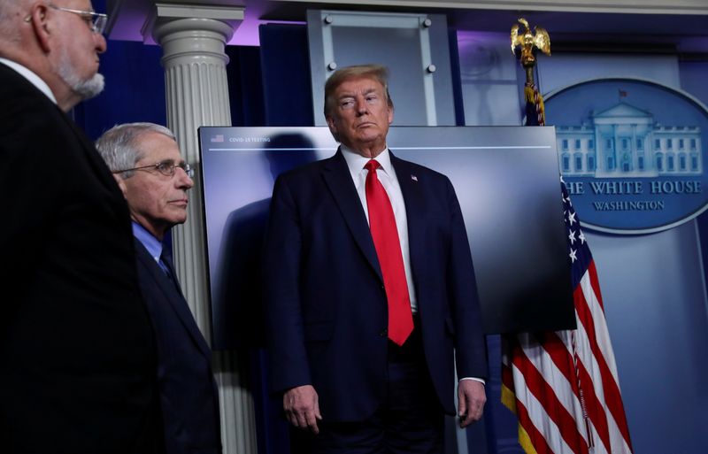 President Trump looks at Dr. Anthony Fauci as he returns