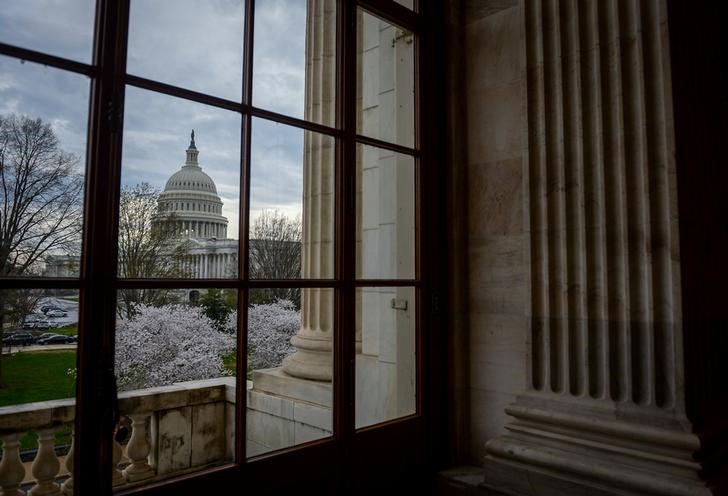 The U.S. Capitol is seen through a window in the
