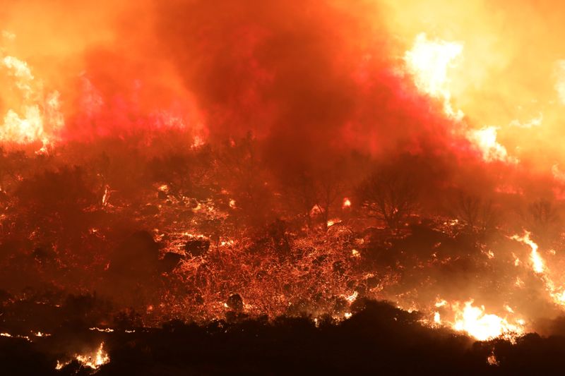 A wildfire dubbed the Cave Fire burns in the hills