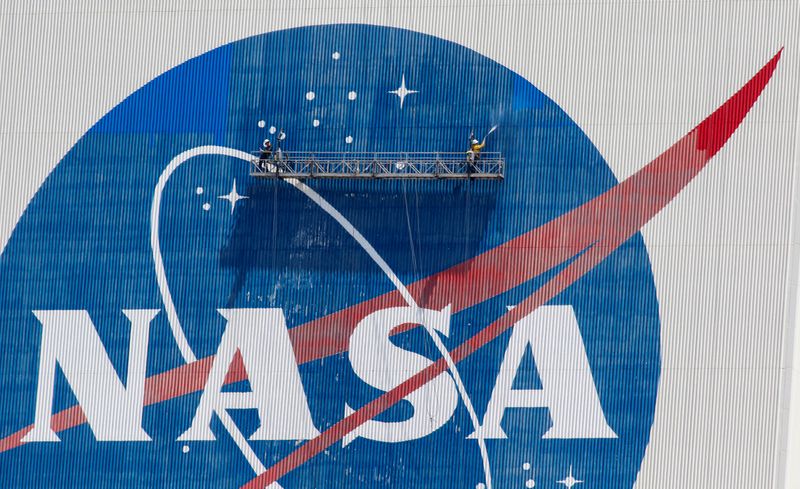 FILE PHOTO: Workers pressure wash the logo of NASA on
