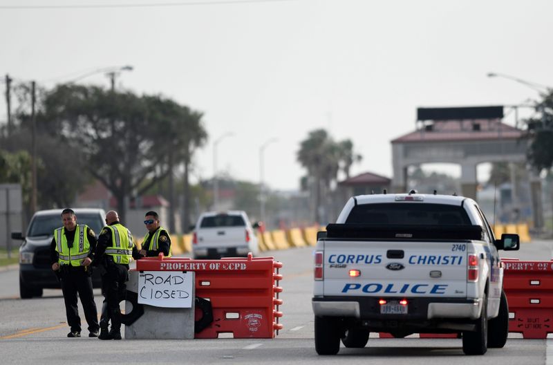Police officers stand at a checkpoint after a shooting incident