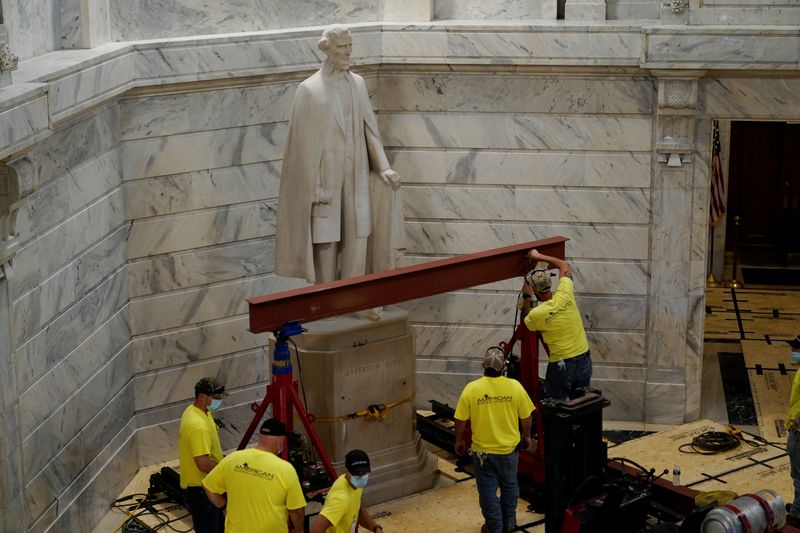 Workers prepare to remove a statue of Confederate President Jefferson