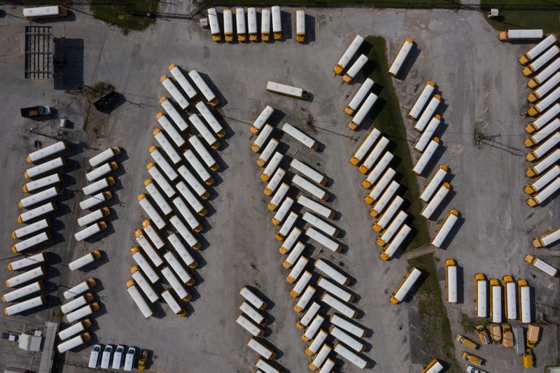 Empty school buses are seen in parking lot amid global