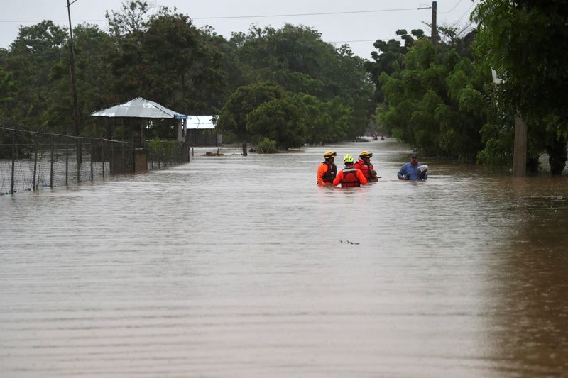 Rescue workers are seen on a flooded street, after Storm