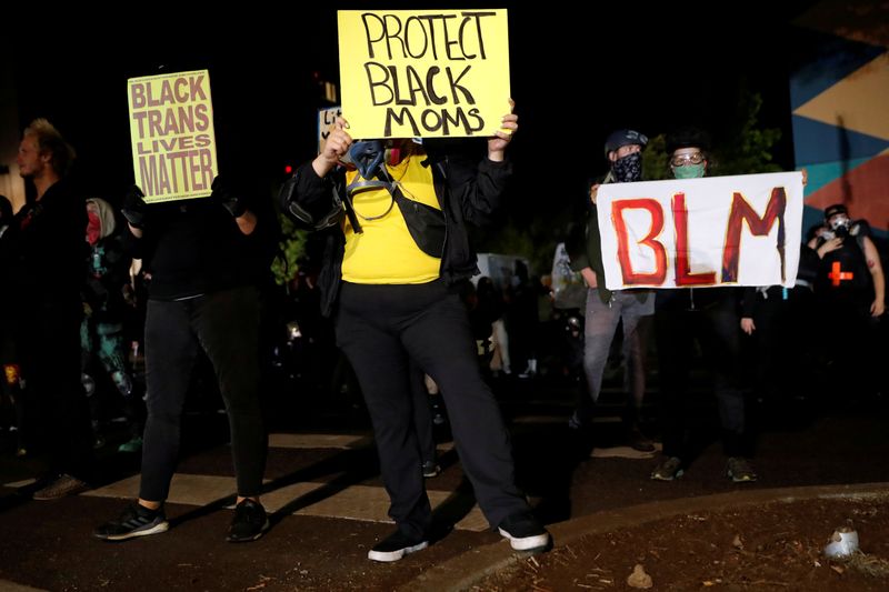 FILE PHOTO: Demonstrators hold signs during a protest against police