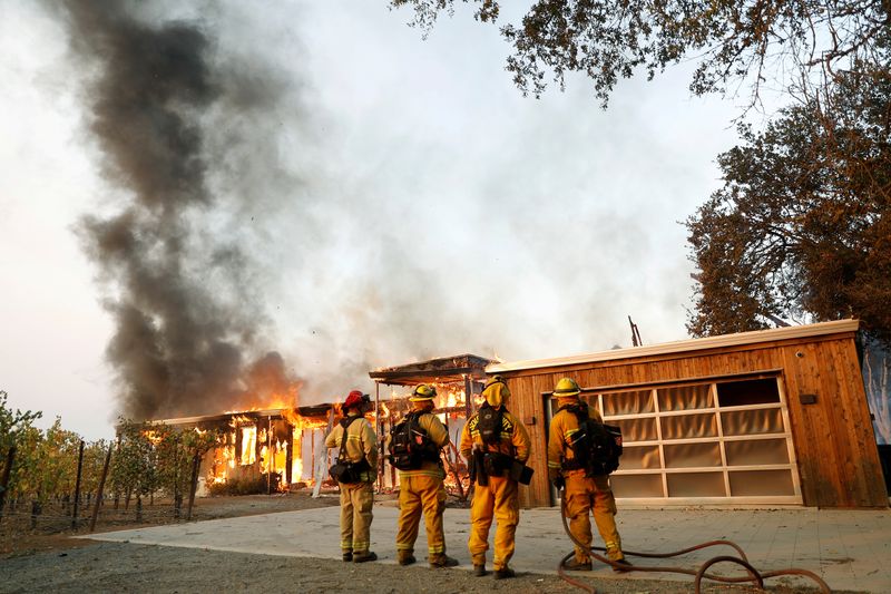 FILE PHOTO: A group of firefighters look on as a
