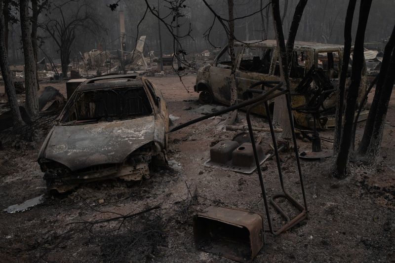 Vehicles lie damaged in the aftermath of the Obenchain Fire