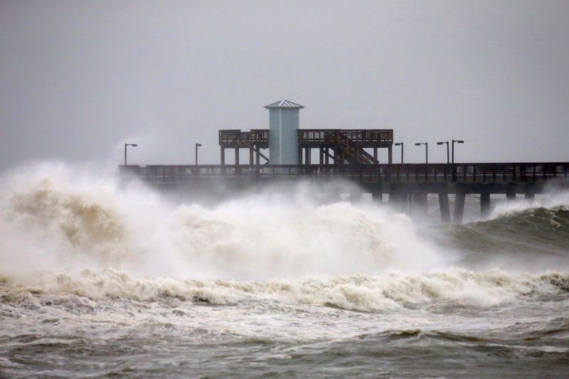 Waves crash along a pier as Hurricane Sally approaches in