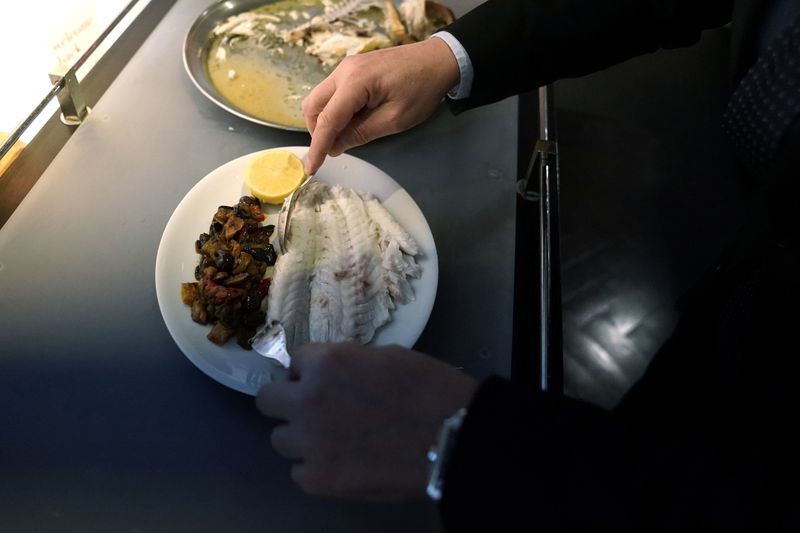 The floor manager of Il Gattopardo restaurant plates a fish