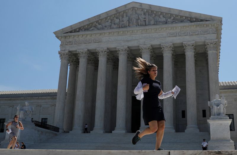 News assistants run outside the U.S. Supreme Court in Washington