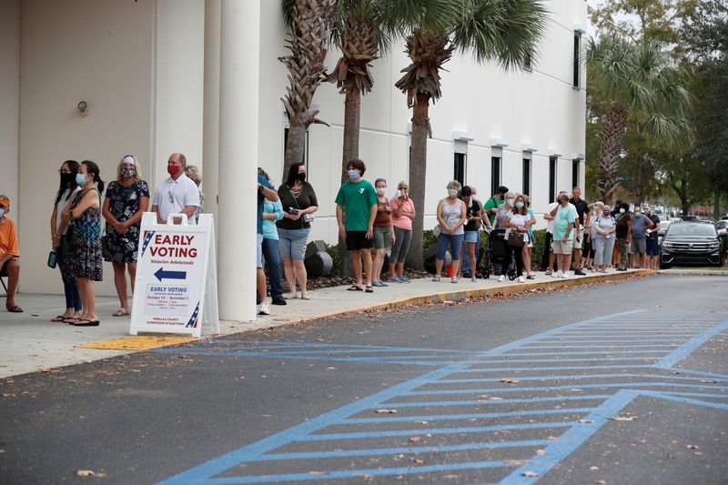 People line up at a polling station as early voting