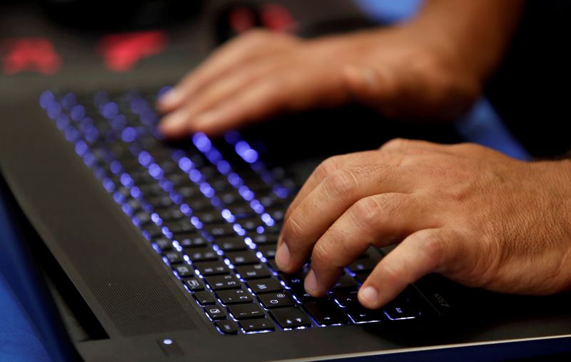 FILE PHOTO: A man types into a keyboard during the