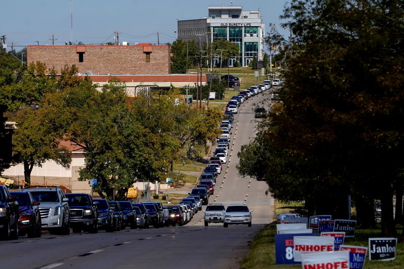 Voters wait in a long line of cars during early