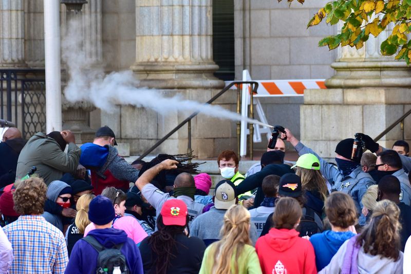 Law enforcement officers spray protesters shortly after a moment of
