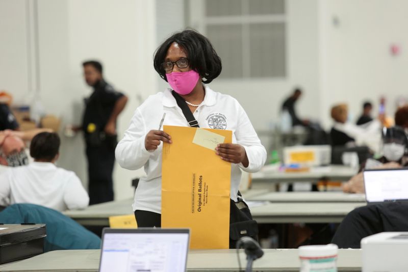 A poll worker supervisor handles an envelope of original ballots