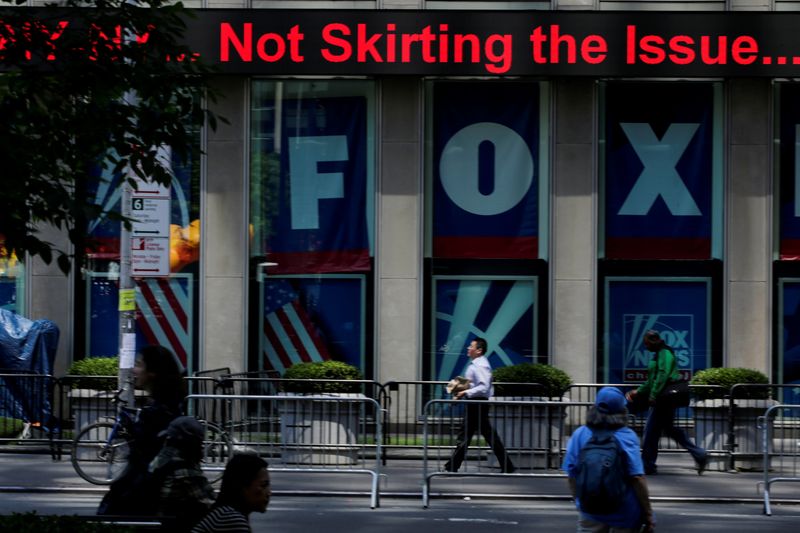 FILE PHOTO: People pass by ads of Fox News channel