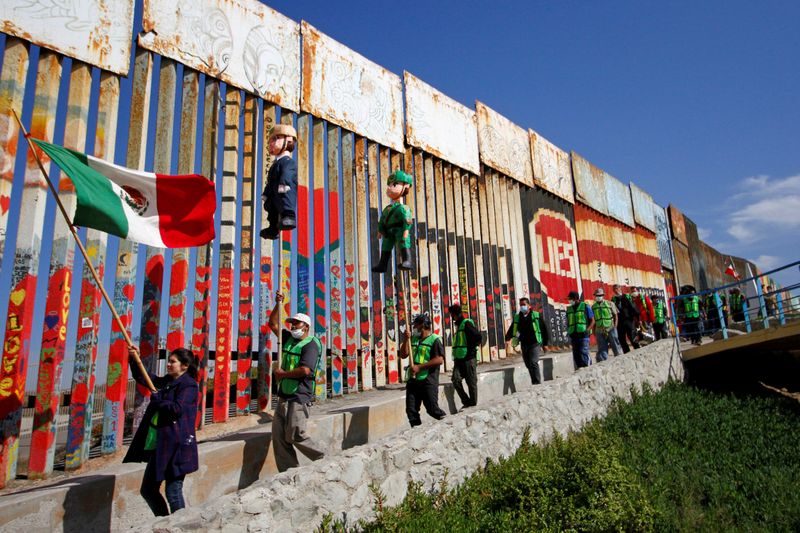 FILE PHOTO: Migrants and members of civil society hold pinatas