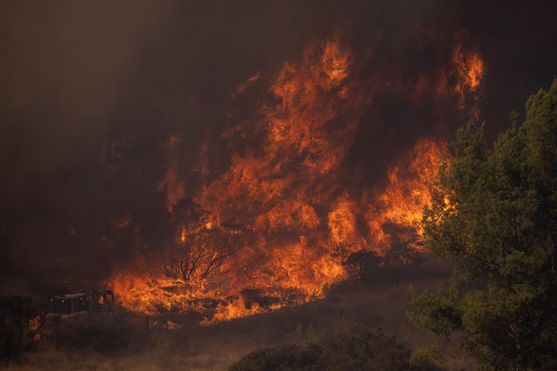 A firefighting bulldozer battles the Bond Fire wildfire near Lake