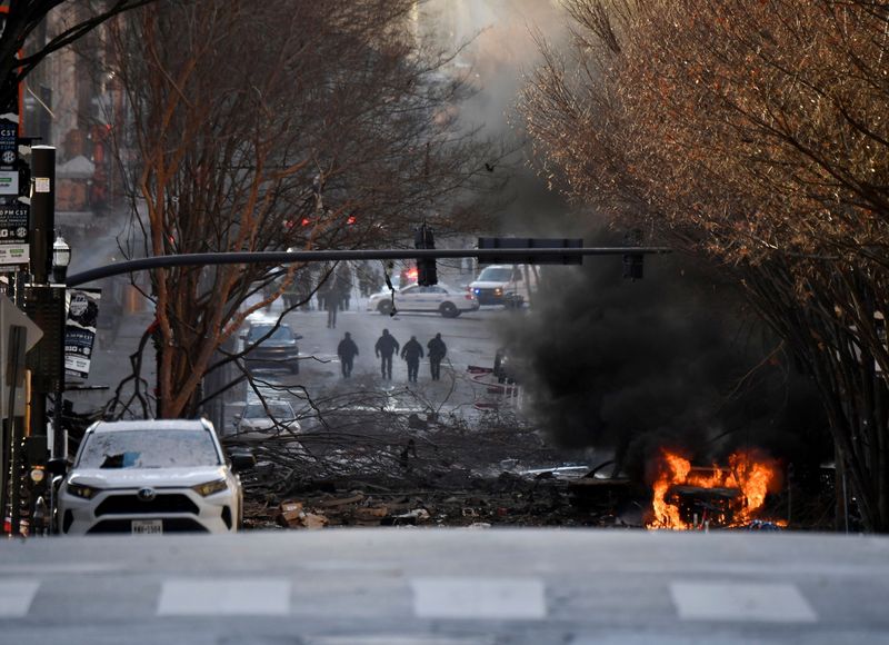 A vehicle burns near the site of an explosion in