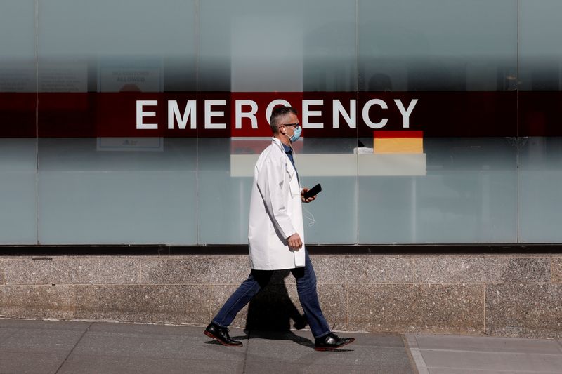 A doctor wears a protective mask as he walks outside