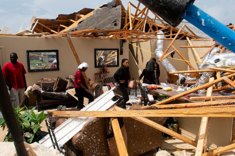 Residents comb through the wreckage of a collapsed house after
