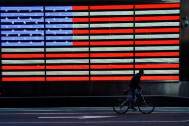 FILE PHOTO: A bicyclist rides through Times Square during evening