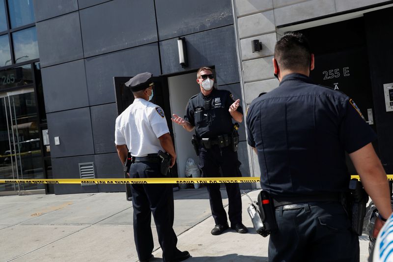 NYPD officers speak at crime scene at 265 Houston Street,