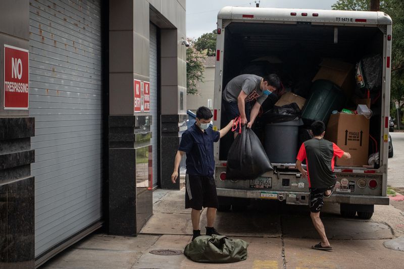 Men load bags full of belongings from China’s Consulate into