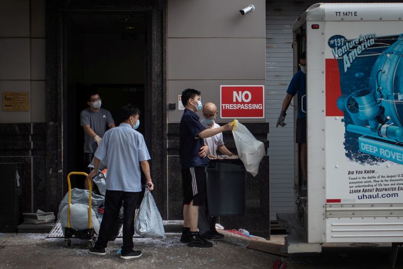 Officials load bags full of belongings from the China’s Consulate