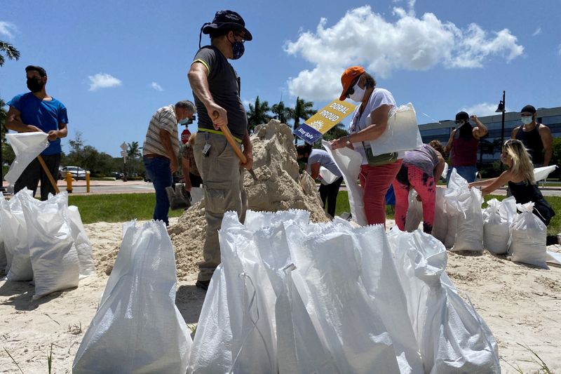 Residents fill and collect sand bags before the expected arrival