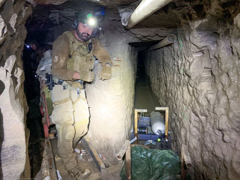 A U.S. Customs and Border Protection agent maps tunnel to