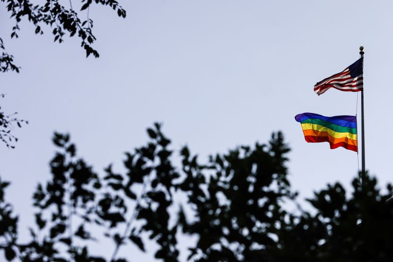 A rainbow pride flag is seen with the U.S. national