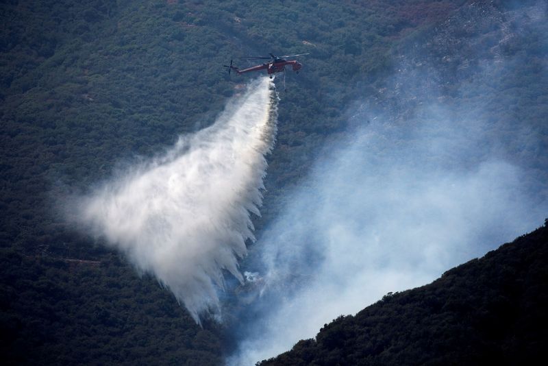 FILE PHOTO: A helicopter makes a water drop over a