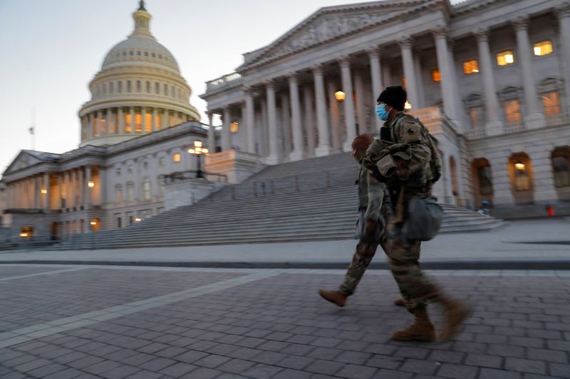 U.S. National Guard members walk near the U.S. Capitol Building