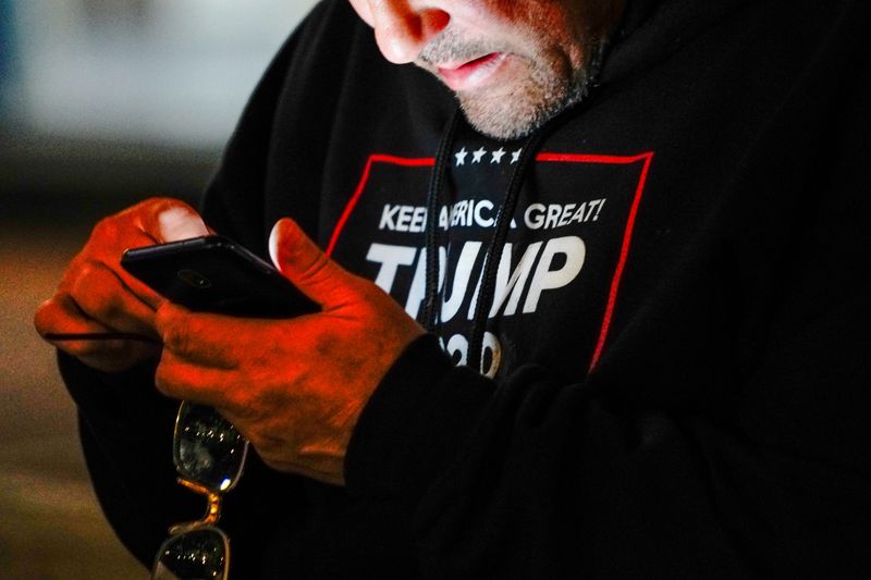 FILE PHOTO: A man wearing a “Trump 2020” sweatshirt uses