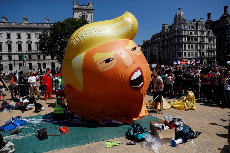 Demonstrators slowly deflate a blimp portraying U.S. President Donald Trump