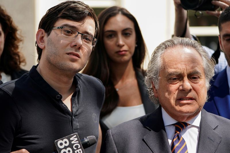 FILE PHOTO: Former drug company executive Martin Shkreli stands with