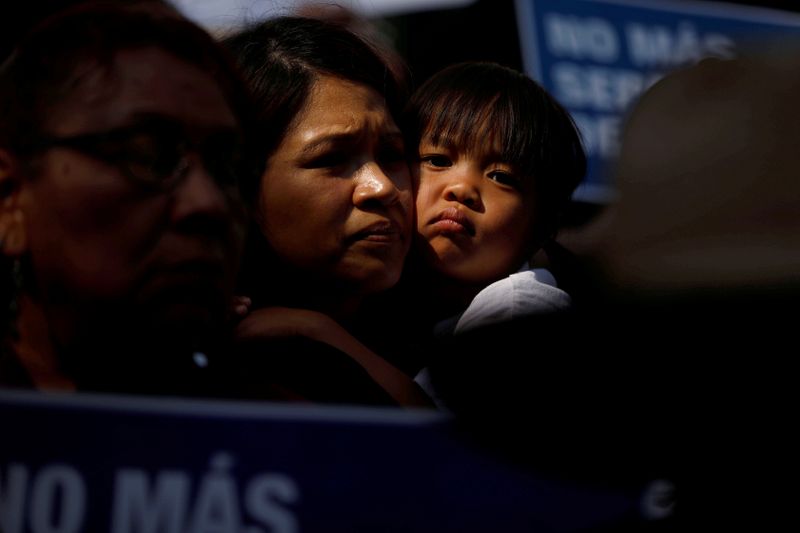 FILE PHOTO: A child embraces a woman as demonstrators hold