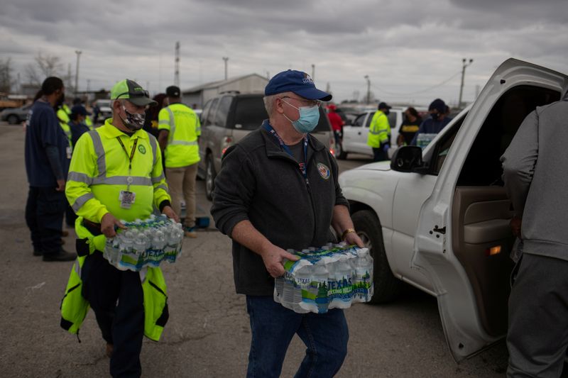 FILE PHOTO: Volunteers give water to residents affectred by