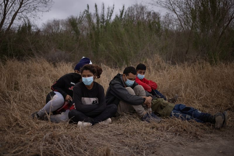 Migrants from Central America await transport after crossing into the
