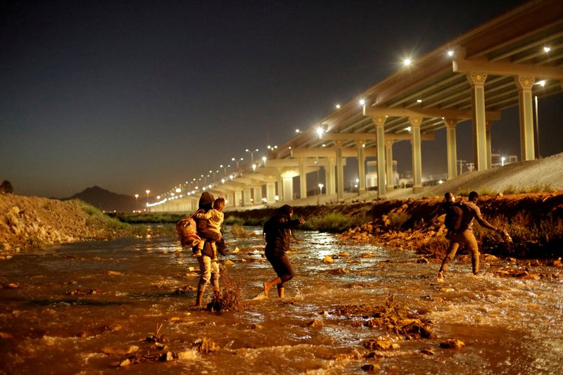FILE PHOTO: Migrants cross the Rio Bravo river to turn