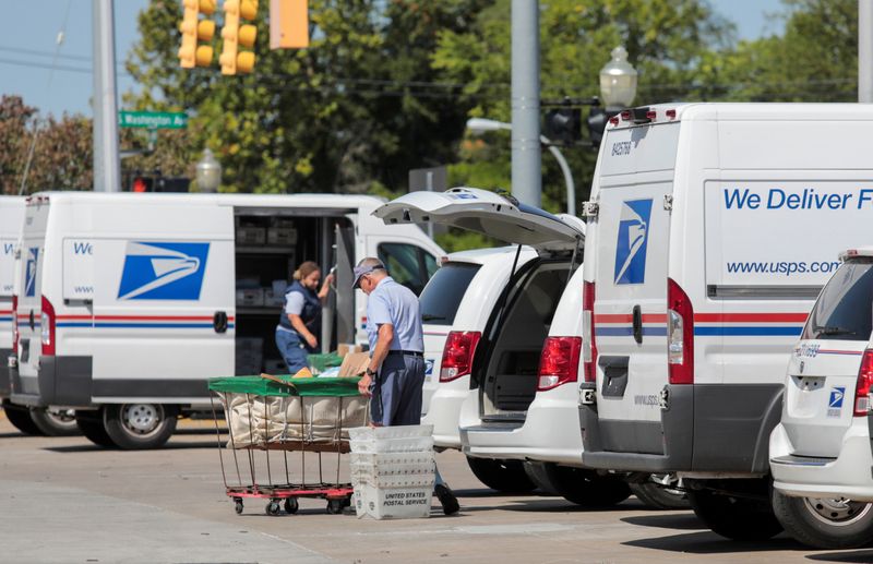 FILE PHOTO: United States Postal Service (USPS) workers load mail