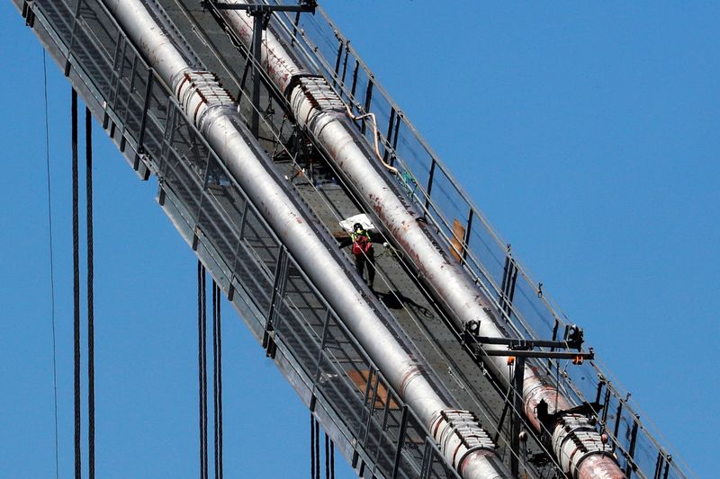 A construction worker scales the northeast cables of the George