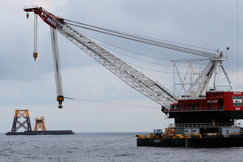 FILE PHOTO: Construction crane floats next to a barge carrying