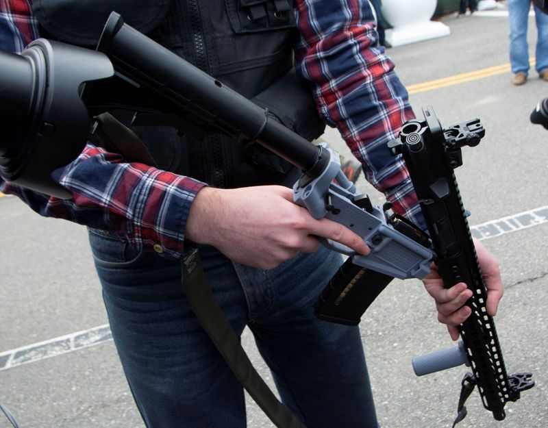 A participant in an armed rally shows a weapon known